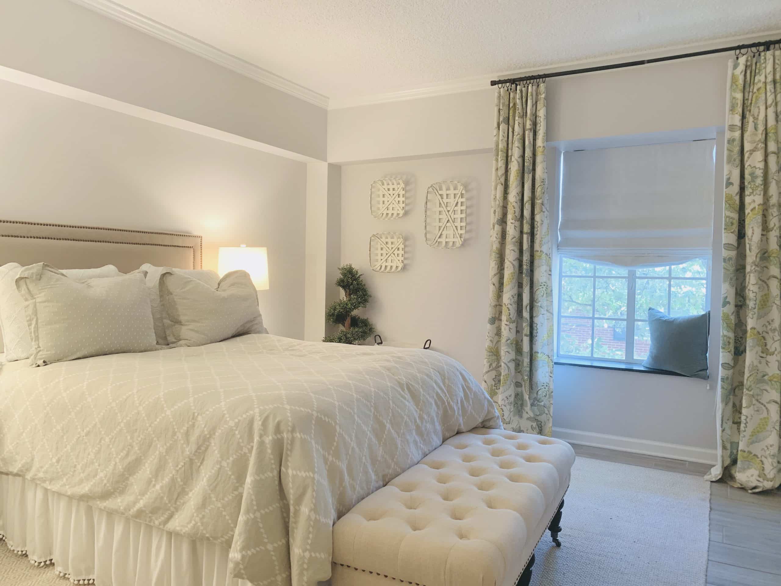 White, Relaxed-style Roman Shades, featuring gentle folds at the bottom of the shade, in a white Buckhead, GA bedroom