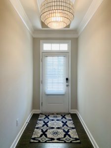 White, Real Wood Blinds on a front door window, featuring 2.5' slats, and light-filtering capability in Cumming, GA