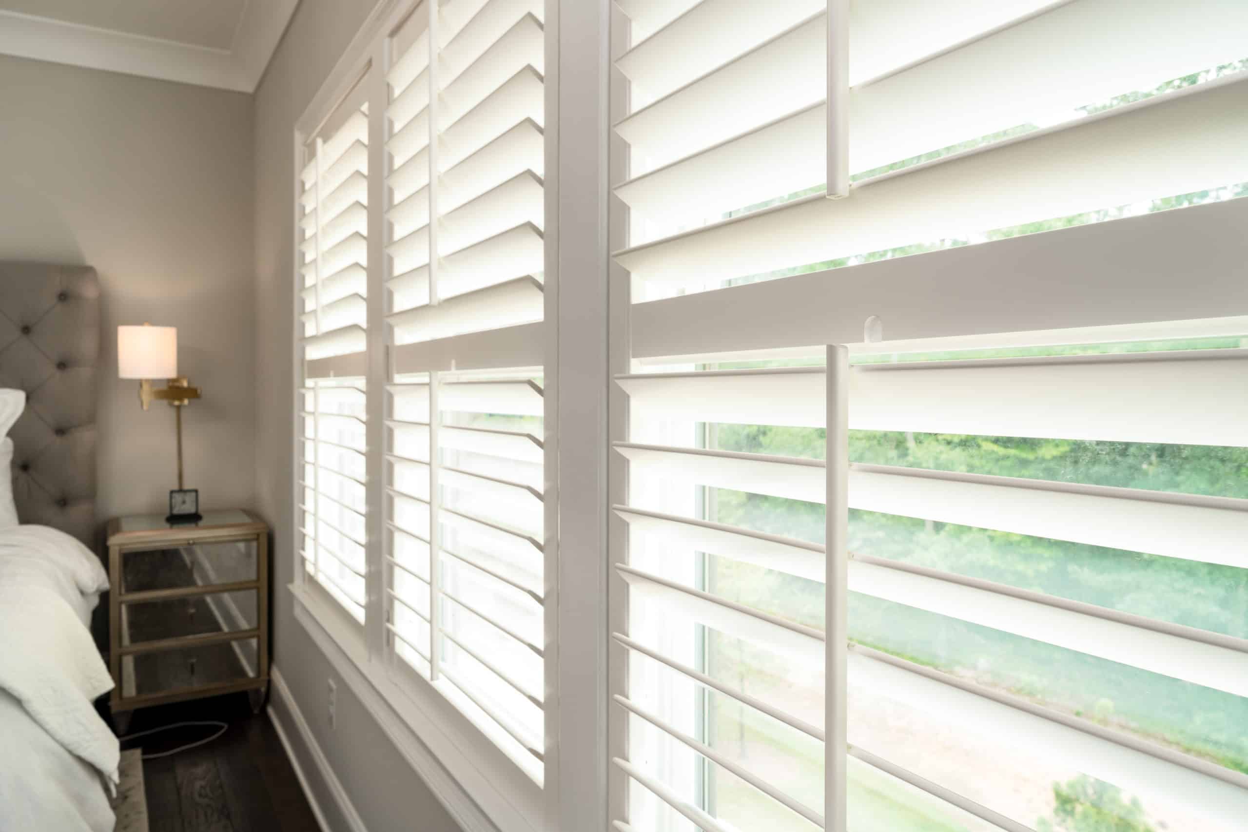 White, Hardwood Plantation Shutters featuring 3.5 inch louvers and divider rails, in a Sandy Springs, GA master suite