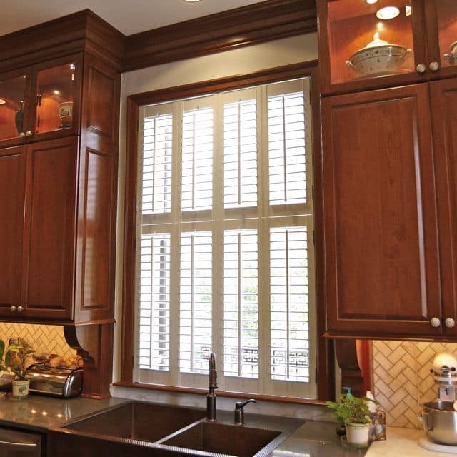 Double-hung, White, Hardwood Plantation Shutters with 3.5 inch louvers above a sink in the newly renovated kitchen of the Georgia Governor's Mansion in Buckhead, GA.