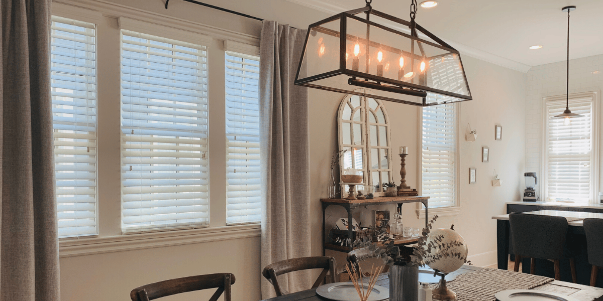 Faux Wood Blinds featuring 2.5 inch slats allow gentle light into this open concept kitchen and dining area