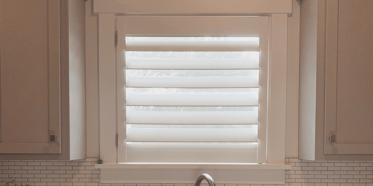 Close up of White Plantation Shutters with 4.5 inch louvers and a hidden tilt rod, also known as Superview Shutters, in a Nashville, TN kitchen.