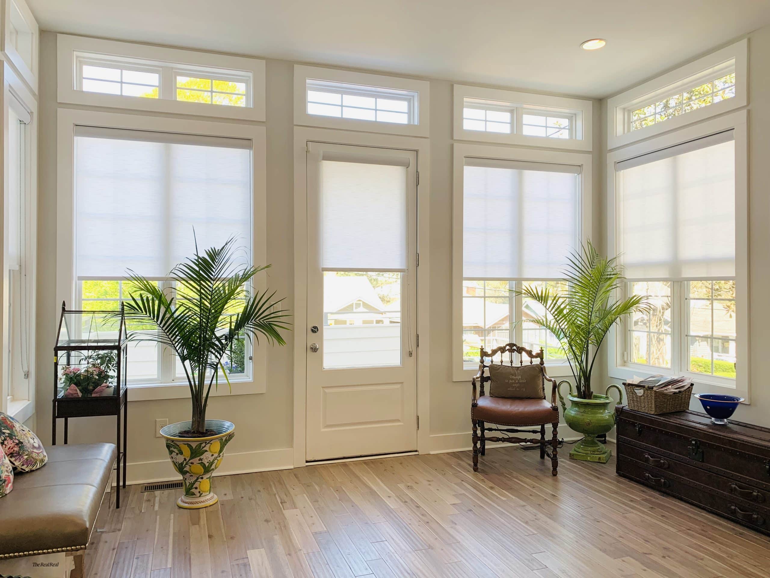 Light filtering Roller Shades in a brightly-lit room white trim and potted plants in Atlanta, GA