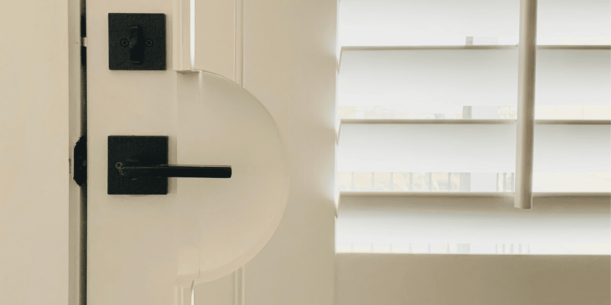 Close up of White Plantation Shutters with 3.5 inch louvers tapered louvers on a door with a handle cut-out