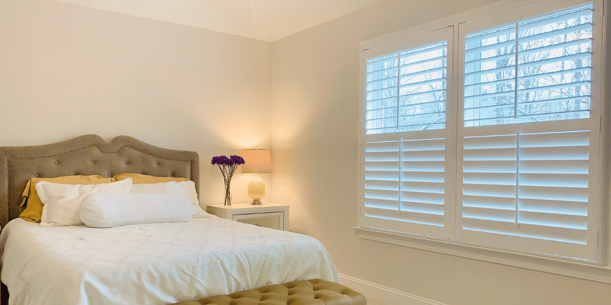 Hardwood Plantation Shutters featuring 3.5 inch louvers and split tilt rods in a cozy, white Roswell, GA bedroom