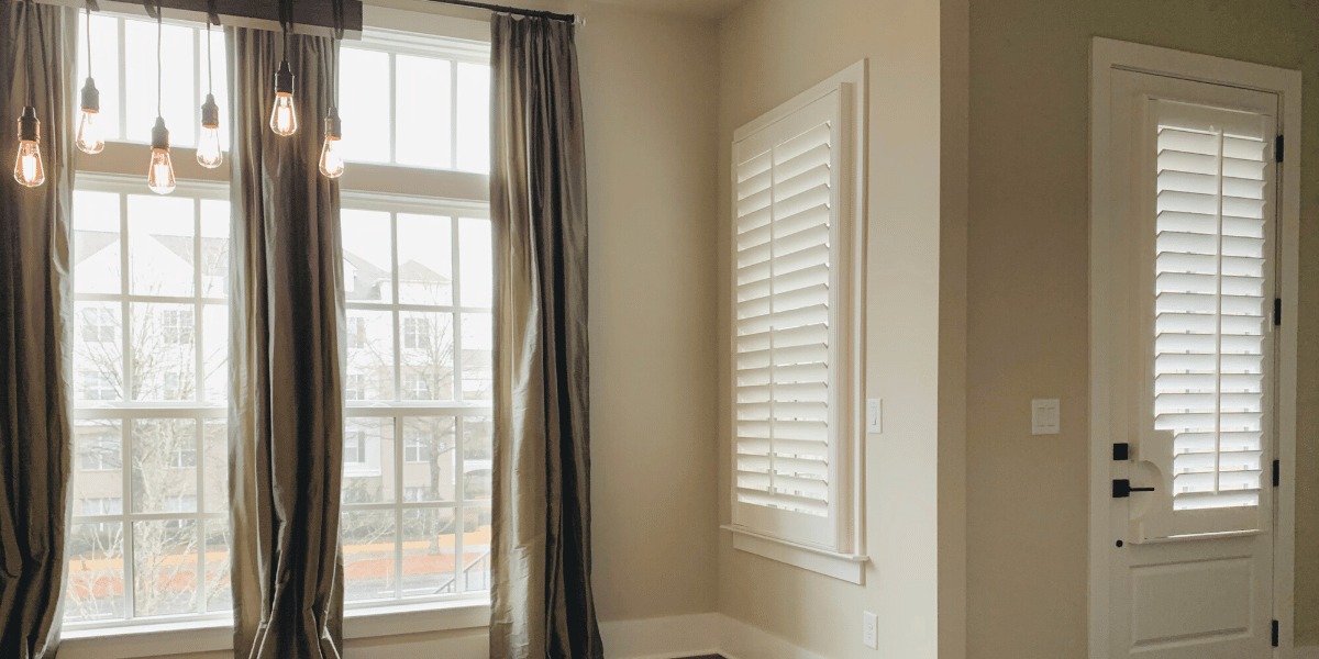 White Hardwood Plantation Shutters featuring 3.5 inch louvers in a spacious, neutral-colored, Alpharetta, GA foyer