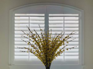 White, Hardwood Plantation Shutters featuring 3.5 inch louvers on a double-paneled, arched window with white trim, in Roswell, GA