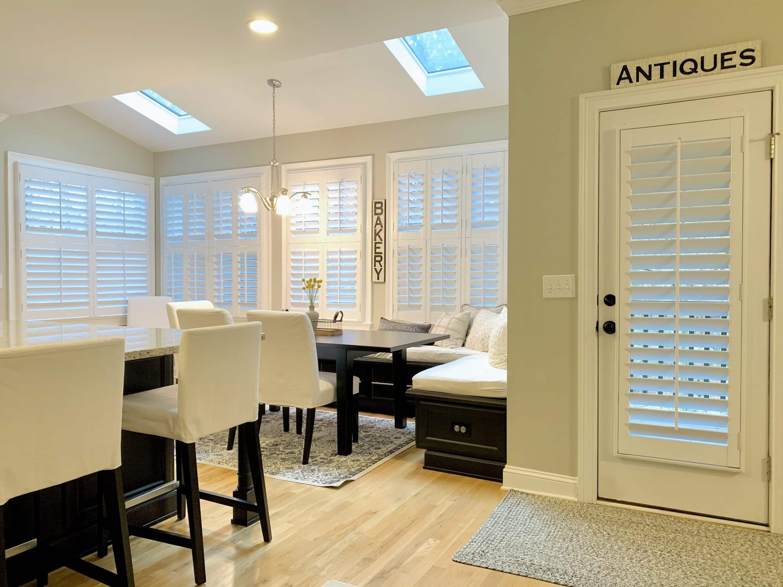 White, Hardwood Plantation Shutters featuring 3.5 inch louvers and split tilt rods in white kitchen and dining area in Decatur, GA