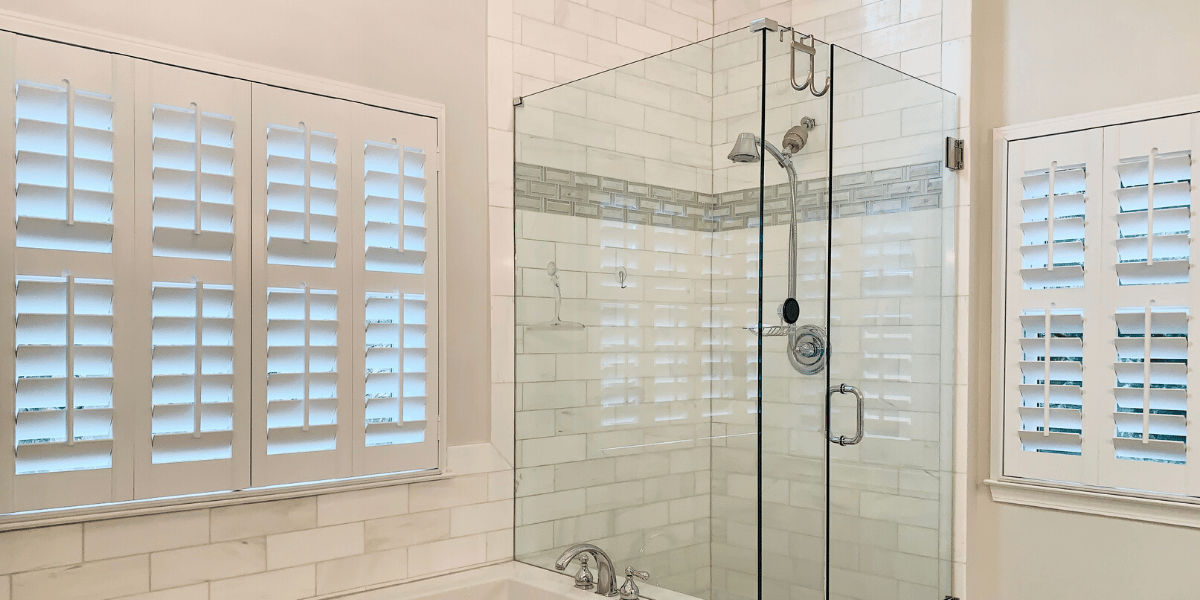 White Hardwood Plantation Shutters featuring 3.5 inch louvers and divider rails gently light this master ensuite bathroom in Decatur, GA