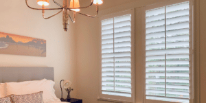 Hardwood Plantation Shutters on two windows featuring split tilt rods in a white-trimmed Atlanta, GA bedroom