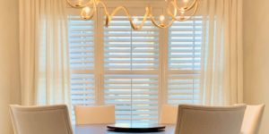 White Plantation Shutters featuring 3.5 inch tapered louvers and divider rails in a warmly lit Nashville, TN dining room