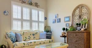 Hardwood Plantation Shutters featuring 2.5 inch louvers and divider rails in a brightly-lit sunroom in Nashville, TN