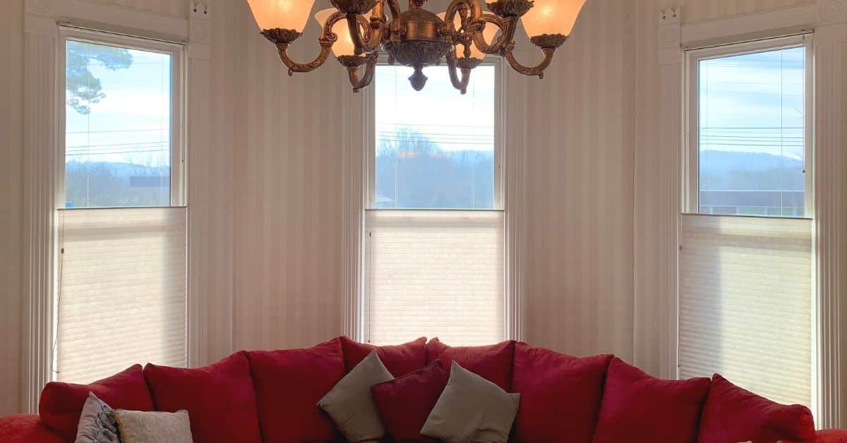 Cellular Shades, also known as Honeycomb Shades, featuring top down, buttom up lift functionality, above a red couch in a historic Woodbury, TN estate