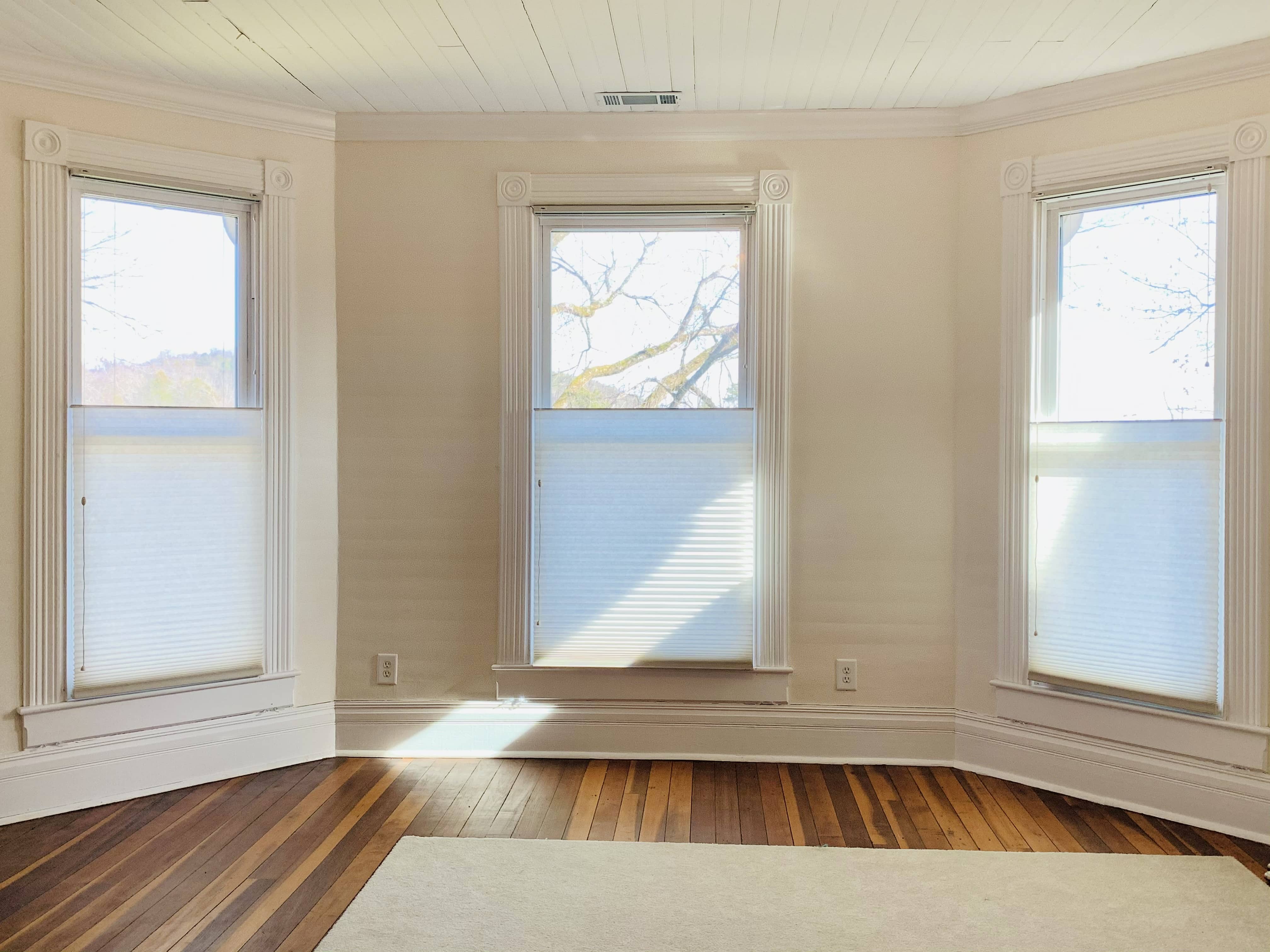 Three top down cellular shades cover three large windows