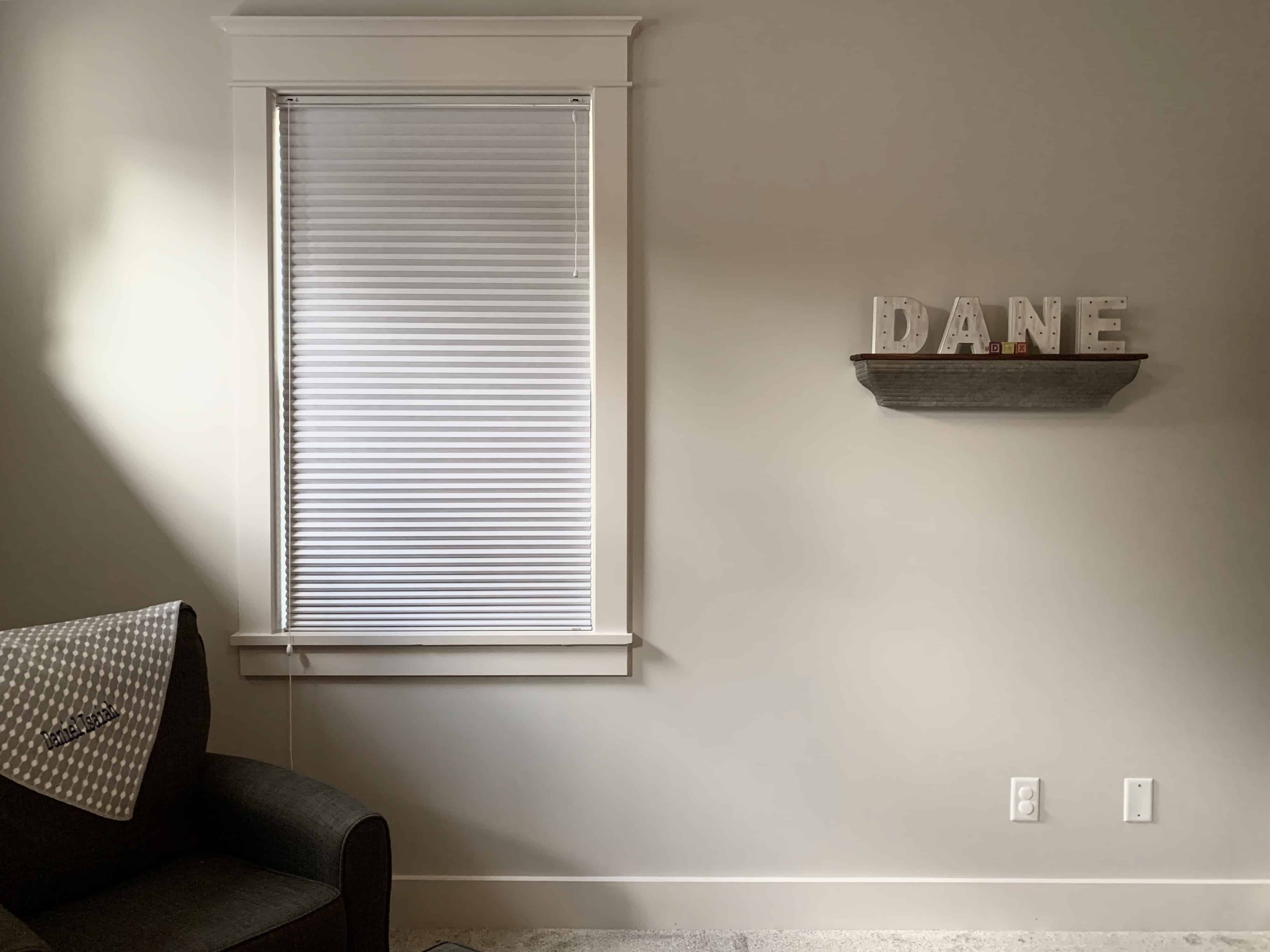 Cellular shades cover a single window in a living room